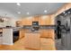 Well-lit kitchen with wooden cabinets, sleek black appliances, and central island at 22801 E Briarwood Pl, Aurora, CO 80016