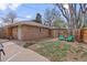Cozy backyard featuring a brick detached garage, wooden fence, and two Adirondack chairs, perfect for outdoor relaxation at 3667 Hudson St, Denver, CO 80207