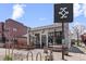 Exterior of Long Table Brewhouse with a sign, picnic tables, barrel decor, and bike parking at 3667 Hudson St, Denver, CO 80207