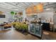 A modern coffee shop featuring a wooden counter, beverage refrigerators, and hanging plant decor at 3667 Hudson St, Denver, CO 80207