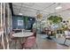 Bright dining area with tables, chairs, and a greenhouse filled with plants at 3667 Hudson St, Denver, CO 80207