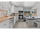 Bright kitchen featuring white cabinets, stainless steel appliances, and a cozy breakfast nook at 3667 Hudson St, Denver, CO 80207