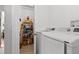 Laundry room with newer washer and dryer, utility sink, and shelving for storage at 3667 Hudson St, Denver, CO 80207