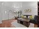 Comfortable living room with hardwood floors, a plush sofa, and natural light from the windows at 3667 Hudson St, Denver, CO 80207