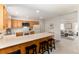 Kitchen features light wood cabinets, modern appliances, and a breakfast bar at 7272 S Miller St, Littleton, CO 80127