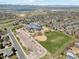 Aerial view showcases a school, athletic fields, and neighborhood, offering easy access and a sense of community at 9763 Cove Creek Dr, Highlands Ranch, CO 80129