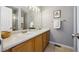 Well-lit bathroom features a double sink vanity with warm wood cabinetry and a neutral color scheme at 9763 Cove Creek Dr, Highlands Ranch, CO 80129