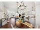 Open-concept kitchen boasts white cabinets, stainless steel appliances, an island, and a dining area with modern light fixtures at 9763 Cove Creek Dr, Highlands Ranch, CO 80129