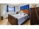 Bright bedroom featuring a wooden bed frame and blue curtains at 1441 E 84Th Pl, Denver, CO 80229