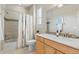 Bathroom features a shower-tub combo, single sink vanity, and wood look tile floors at 7770 Owl Creek Cir, Littleton, CO 80125