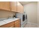 Convenient laundry room featuring a sink, cabinets, and a modern washer and dryer set at 7770 Owl Creek Cir, Littleton, CO 80125