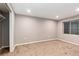 Recently finished basement area with a large window and neutral walls and carpet at 5294 S Espana St, Centennial, CO 80015