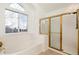 Bathroom featuring a window, tub, and separate shower with gold trim, creating a luxurious and spa-like experience at 5294 S Espana St, Centennial, CO 80015