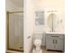 Bright bathroom featuring a glass enclosed shower and grey vanity with oval mirror at 5294 S Espana St, Centennial, CO 80015