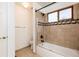 Bathroom featuring a tiled shower-tub combo, vanity, and open storage for toiletries at 5294 S Espana St, Centennial, CO 80015