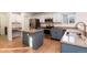 Charming kitchen with stainless steel appliances, an island, and blue lower cabinetry at 5294 S Espana St, Centennial, CO 80015