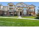 Three-story building with balconies, landscaping, and brick accents at 5733 N Gibralter Way # 3-202, Aurora, CO 80019