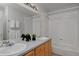 Bathroom vanity featuring double sinks, warm cabinets, and shower/tub combo at 2500 Lexington St, Lafayette, CO 80026