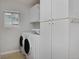 Convenient laundry room with front-loading washer and dryer, storage cabinets, and a window at 2500 Lexington St, Lafayette, CO 80026