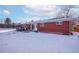 View of back of house and snowy yard at 5986 S Cook St, Littleton, CO 80121