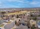 Wide aerial shot displaying a residential area with golf course, lake and mountain views in the distance at 7084 Moss Ct, Arvada, CO 80007