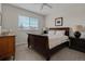 Spacious bedroom with a wooden bed frame, dresser, and natural light from the window at 7084 Moss Ct, Arvada, CO 80007