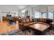 Bright living room with large windows, a leather sofa, and a view into the kitchen at 7084 Moss Ct, Arvada, CO 80007