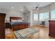 Main bedroom with hardwood floors, a ceiling fan, and large windows overlooking a backyard at 7084 Moss Ct, Arvada, CO 80007