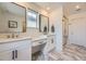 Bright bathroom featuring double sinks, stylish mirrors, and a glass-enclosed shower at 15210 W Eastman Ave, Morrison, CO 80465