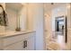 Bright bathroom with white vanity, stone countertop, and tiled shower-tub combo at 15210 W Eastman Ave, Morrison, CO 80465