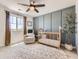 Cozy Bedroom featuring a wooden crib, comfortable chair, and bright window with natural light at 15210 W Eastman Ave, Morrison, CO 80465