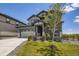 View of a two-story home with neutral-toned exterior, manicured lawn and young tree in the front yard at 15210 W Eastman Ave, Morrison, CO 80465