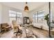 Bright home office featuring a glass-top desk, ergonomic chair, and large windows with neighborhood views at 15210 W Eastman Ave, Morrison, CO 80465