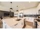 Modern kitchen with white cabinets, a spacious island, stainless steel appliances, and a view into the living area at 15210 W Eastman Ave, Morrison, CO 80465