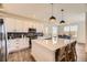 Bright kitchen with white cabinets, a large island with seating, stainless steel appliances, and modern pendant lights at 15210 W Eastman Ave, Morrison, CO 80465