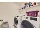 Modern laundry room with front load washer and dryer, plus storage shelves at 15210 W Eastman Ave, Morrison, CO 80465