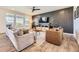 Stylish living room with modern furniture, wood accent wall, lots of natural light, and wood flooring at 15210 W Eastman Ave, Morrison, CO 80465