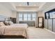 Beautiful main bedroom with a ceiling fan, TV, and large windows overlooking the landscape at 15210 W Eastman Ave, Morrison, CO 80465