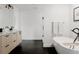Modern bathroom featuring a soaking tub, black hexagon tile floors, and a floating vanity at 2645 Eudora St, Denver, CO 80207