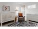 Bright and cozy Bedroom with a crib, rocking chair, and changing table in a well-lit room at 2645 Eudora St, Denver, CO 80207