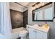 Contemporary bathroom featuring a vanity sink, toilet and shower-tub with dark tile surround and rainfall shower head at 68 S Moline St, Aurora, CO 80012