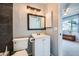 A well-lit bathroom features a modern vanity and a dark-tiled accent wall for a contemporary aesthetic at 68 S Moline St, Aurora, CO 80012
