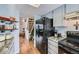 Kitchen featuring wood floors, gray cabinets, a black fridge, marble counters, and stainless steel appliances at 68 S Moline St, Aurora, CO 80012