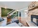 Open-concept living room with a stone fireplace, hardwood floors, and staircase access at 68 S Moline St, Aurora, CO 80012