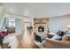 Inviting living room features a stone fireplace, wood floors, and an open layout to the kitchen at 68 S Moline St, Aurora, CO 80012