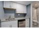Basement kitchenette featuring white cabinets, a granite countertop, a sink, and a mini fridge at 1150 W 127Th Ct, Denver, CO 80234