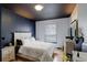 Modern bedroom featuring a white bed frame, dark blue accent wall, and hardwood flooring at 1150 W 127Th Ct, Denver, CO 80234
