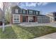 Charming two-story home with brick and green siding, a well-manicured lawn and a two car garage at 1150 W 127Th Ct, Denver, CO 80234