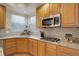Close up of the kitchen area featuring stainless steel appliances, granite countertops, and wood cabinets at 1150 W 127Th Ct, Denver, CO 80234