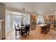 Open kitchen and dining area featuring wood cabinets, stainless steel appliances, and a granite island with seating at 1150 W 127Th Ct, Denver, CO 80234